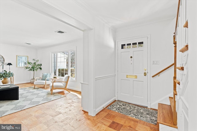 foyer entrance with light parquet floors and ornamental molding