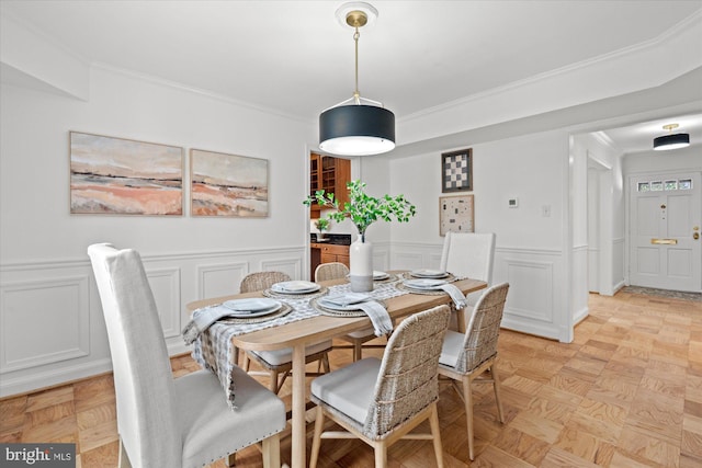 dining room featuring ornamental molding and light parquet flooring