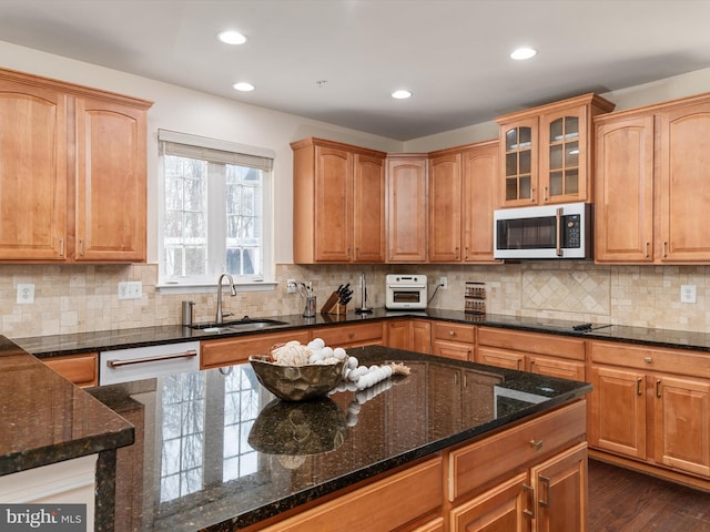 kitchen featuring sink, dark wood-type flooring, black electric stovetop, decorative backsplash, and dark stone counters