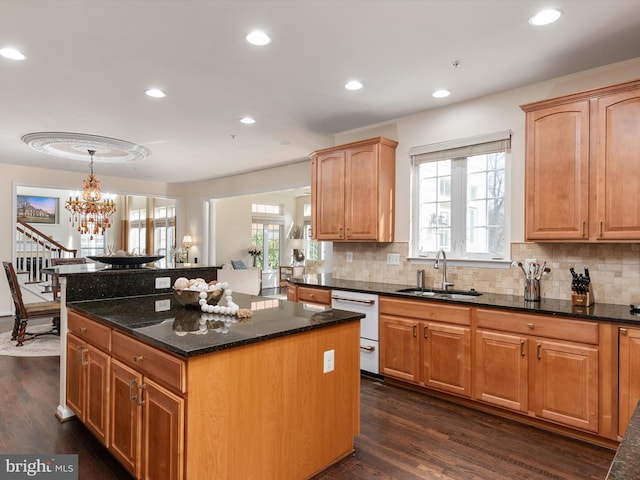 kitchen featuring sink, dark hardwood / wood-style floors, dark stone counters, and a kitchen island