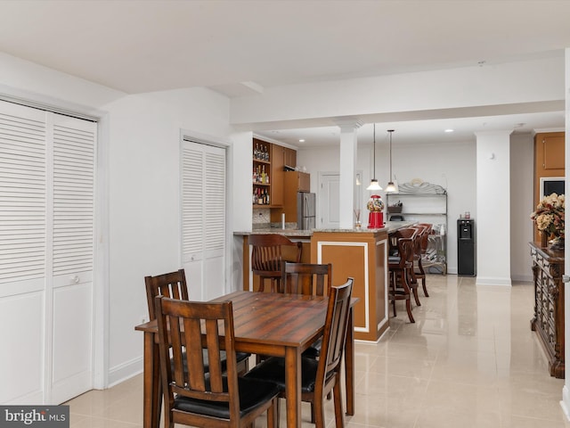 tiled dining room featuring decorative columns