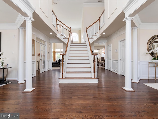 foyer entrance with dark hardwood / wood-style floors and decorative columns