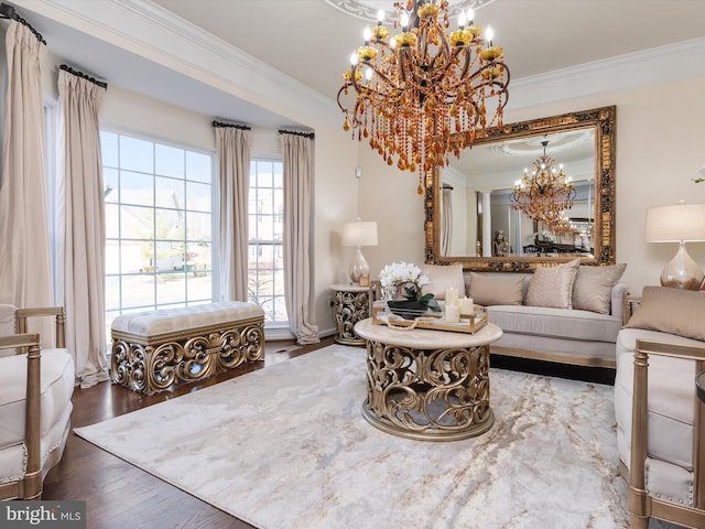 living room with hardwood / wood-style flooring, ornamental molding, and a notable chandelier