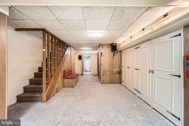 basement featuring wood walls