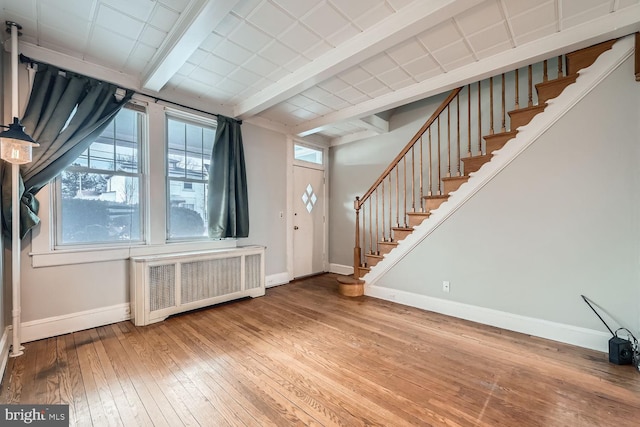 foyer entrance with radiator heating unit and wood-type flooring