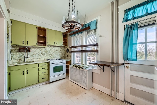 kitchen with sink, backsplash, green cabinets, a notable chandelier, and white gas stove