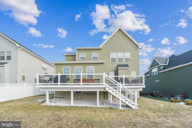 rear view of house featuring a yard and a deck