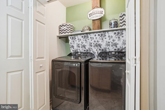 clothes washing area featuring tile patterned flooring and separate washer and dryer