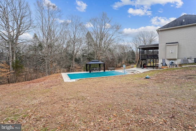 exterior space featuring a patio, central air condition unit, a gazebo, a sunroom, and a covered pool