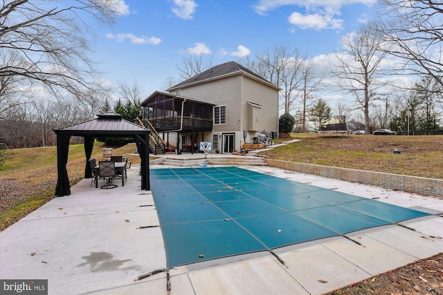 view of pool with a gazebo, a sunroom, a yard, and a patio area