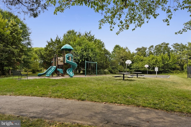 view of play area featuring a lawn and basketball hoop