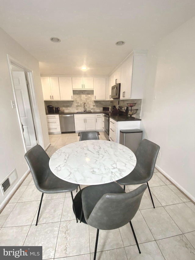 dining room featuring light tile patterned flooring, visible vents, and baseboards