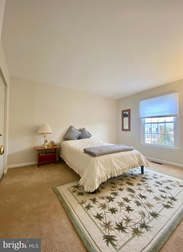 bedroom with carpet floors, visible vents, and baseboards