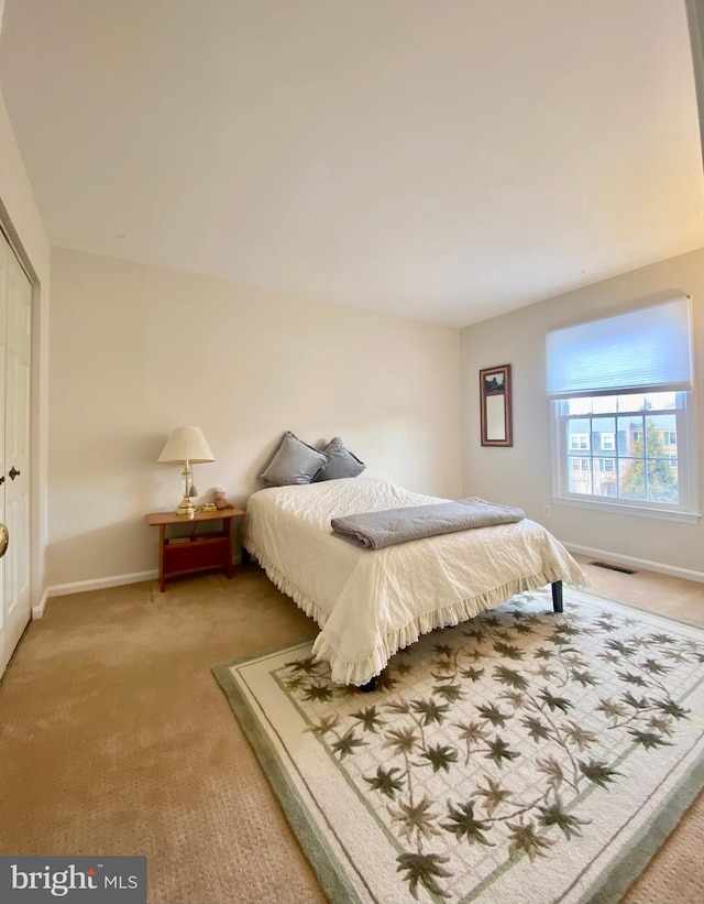 bedroom featuring carpet floors, a closet, visible vents, and baseboards