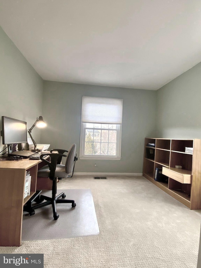 office space featuring light carpet, visible vents, and baseboards