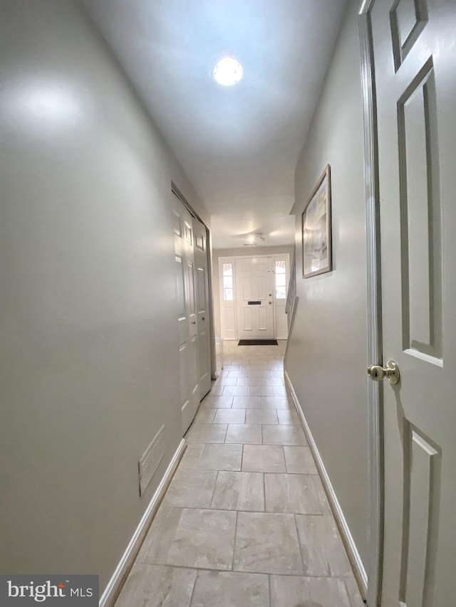 corridor featuring visible vents and baseboards