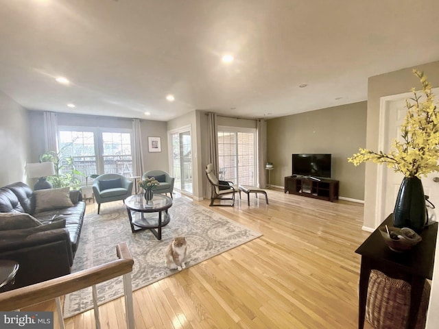 living room featuring light wood finished floors, baseboards, and recessed lighting