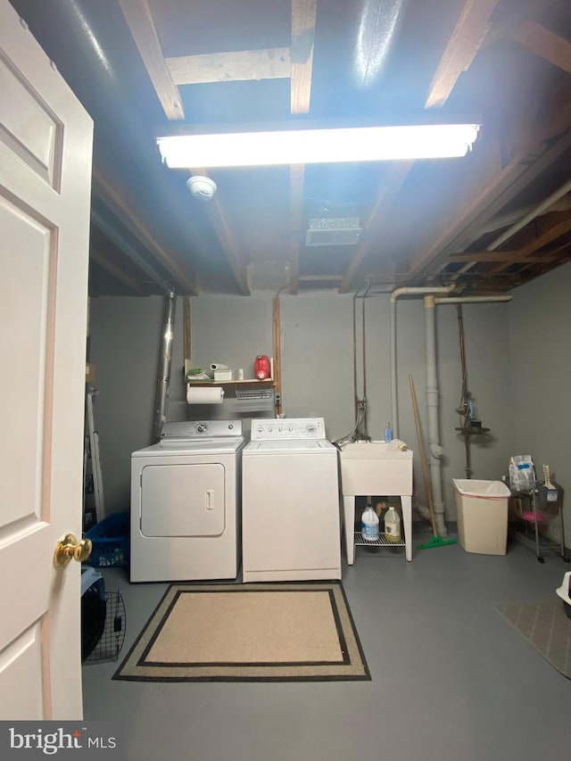 laundry area with laundry area, washer and clothes dryer, and a sink