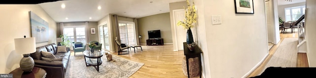 living area featuring light wood-style floors, plenty of natural light, and baseboards