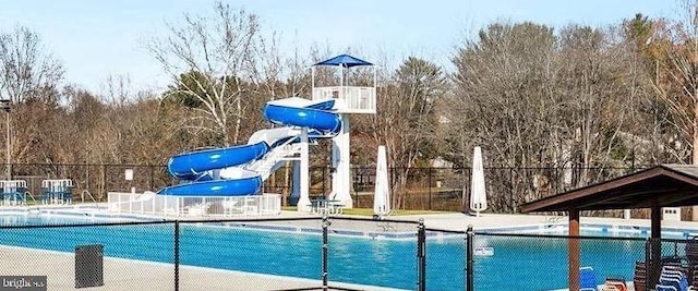 pool featuring a water slide and fence