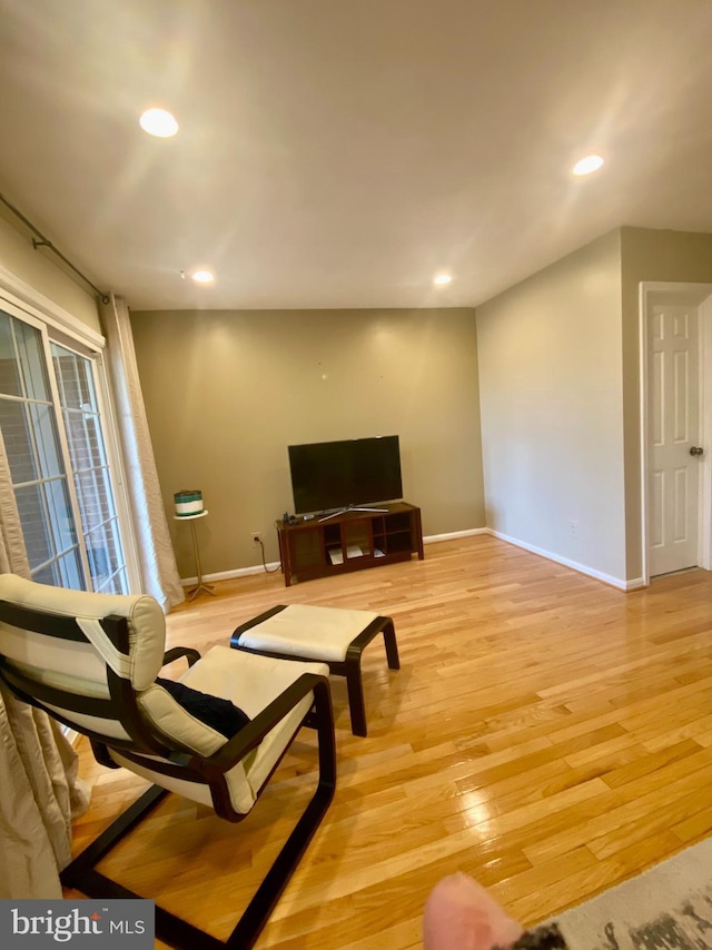 living room featuring light wood-type flooring, baseboards, and recessed lighting