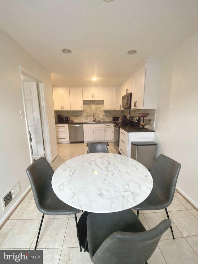 dining area featuring light tile patterned floors, visible vents, and baseboards