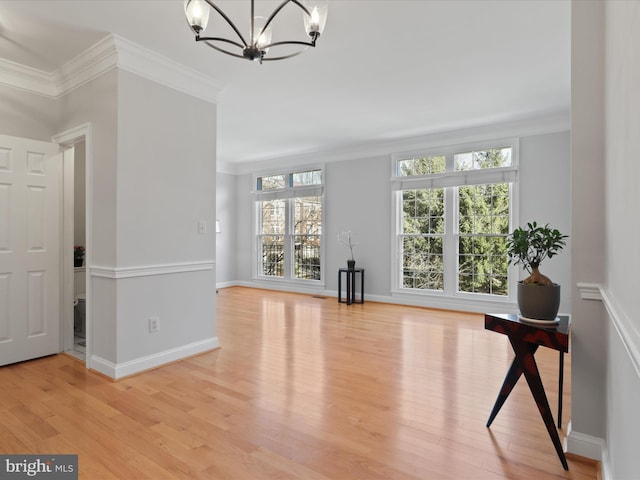 interior space with crown molding, an inviting chandelier, and light wood-type flooring