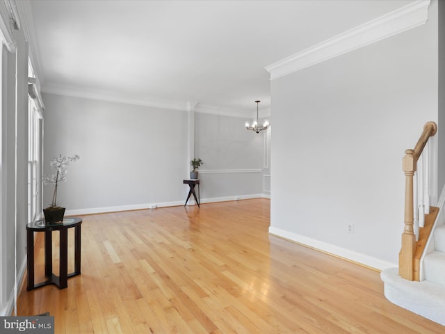 unfurnished living room featuring an inviting chandelier, ornamental molding, and light hardwood / wood-style flooring