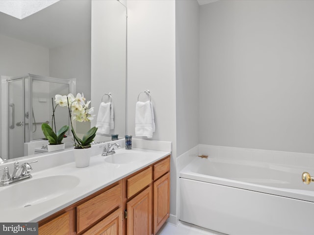 bathroom with vanity, shower with separate bathtub, and a skylight