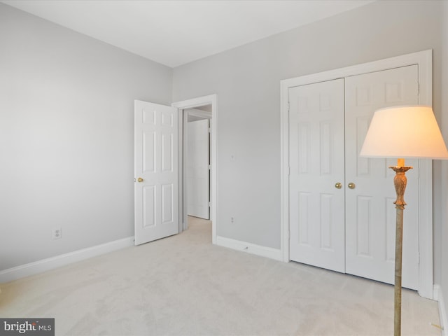 unfurnished bedroom with a closet and light carpet