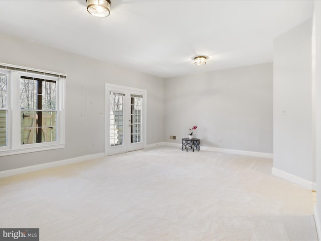 carpeted spare room with french doors and a healthy amount of sunlight