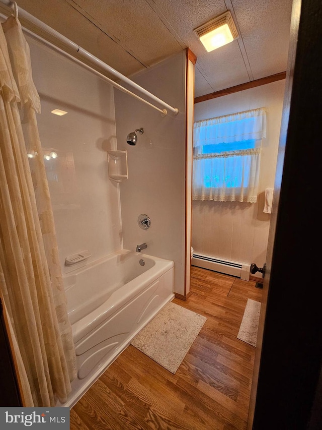 bathroom featuring a baseboard radiator, ornamental molding, hardwood / wood-style floors, and shower / bath combo with shower curtain