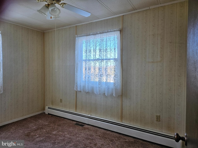 carpeted spare room featuring a baseboard radiator and ceiling fan