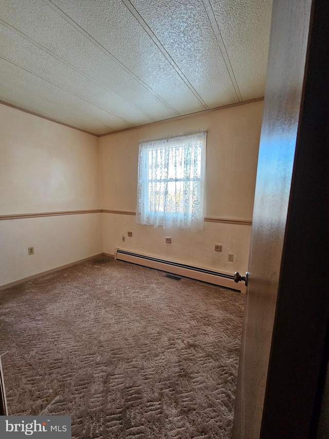 spare room featuring carpet floors, a textured ceiling, and baseboard heating