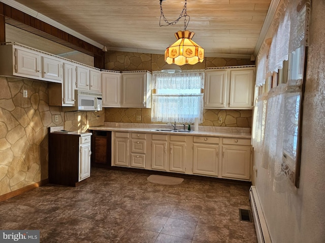 kitchen with pendant lighting, sink, crown molding, a baseboard heating unit, and white cabinets