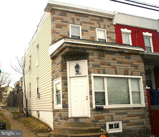 view of front facade featuring entry steps and stone siding