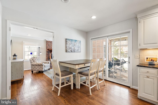 dining space featuring wood-type flooring and ornamental molding