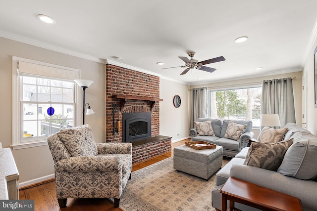 living room featuring ornamental molding, a brick fireplace, ceiling fan, and light hardwood / wood-style floors