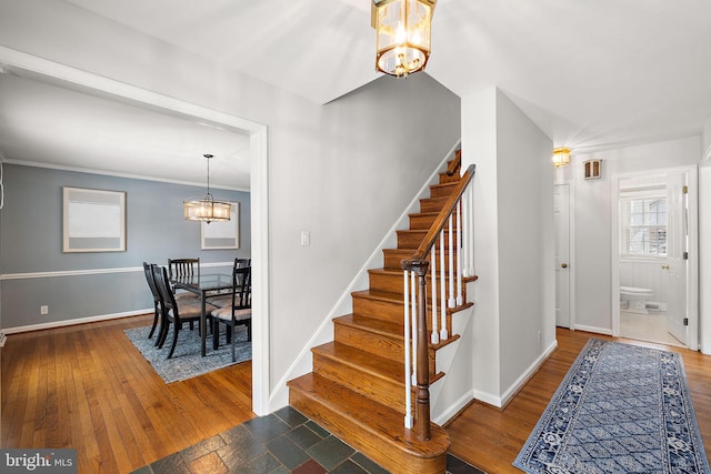 stairs with a notable chandelier and wood-type flooring