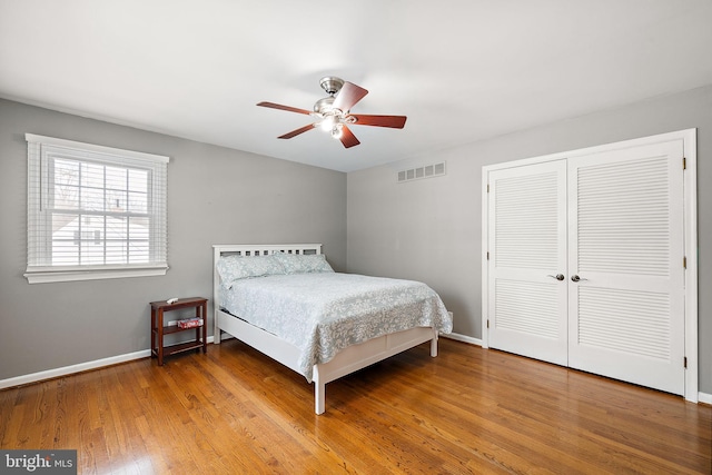 bedroom with hardwood / wood-style flooring, a closet, and ceiling fan