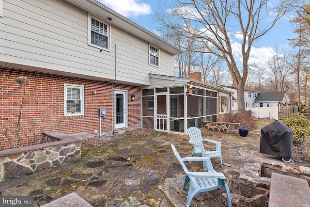 back of property featuring a sunroom and a patio area