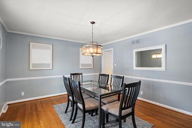 dining room with ornamental molding and hardwood / wood-style floors