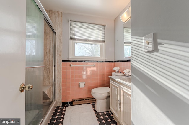 1 Keats Dr, Claymont, DE 19703 - bathroom featuring a shower with shower door, tile walls, vanity, baseboard heating, and toilet