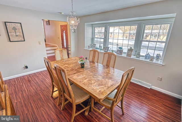 dining area featuring an inviting chandelier and dark hardwood / wood-style floors