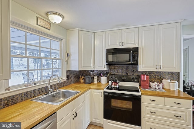 kitchen with wood counters, sink, electric range, and white cabinets