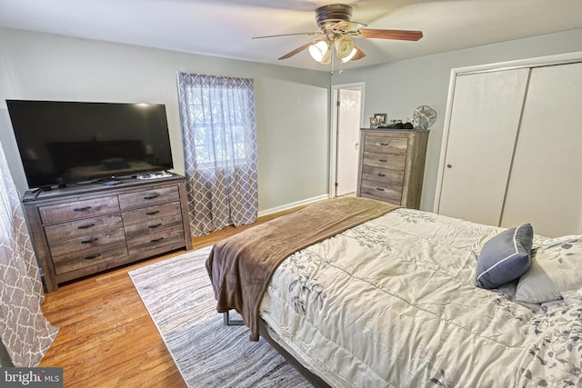 bedroom with ceiling fan, a closet, and light wood-type flooring