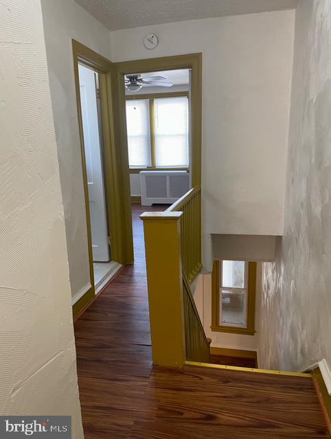 hallway with dark hardwood / wood-style flooring and a textured ceiling