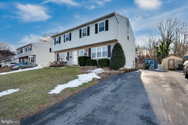 view of front of house featuring a front yard and a storage unit