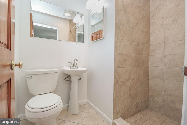 bathroom featuring tiled shower, tile patterned floors, and toilet