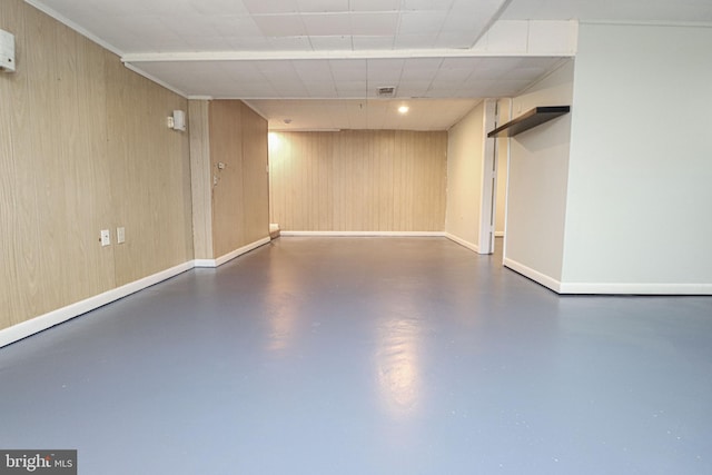 basement featuring wood walls